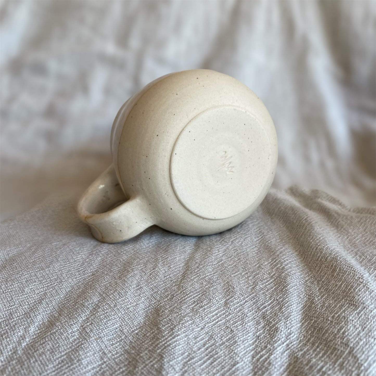 White ceramic mug on a textured beige surface