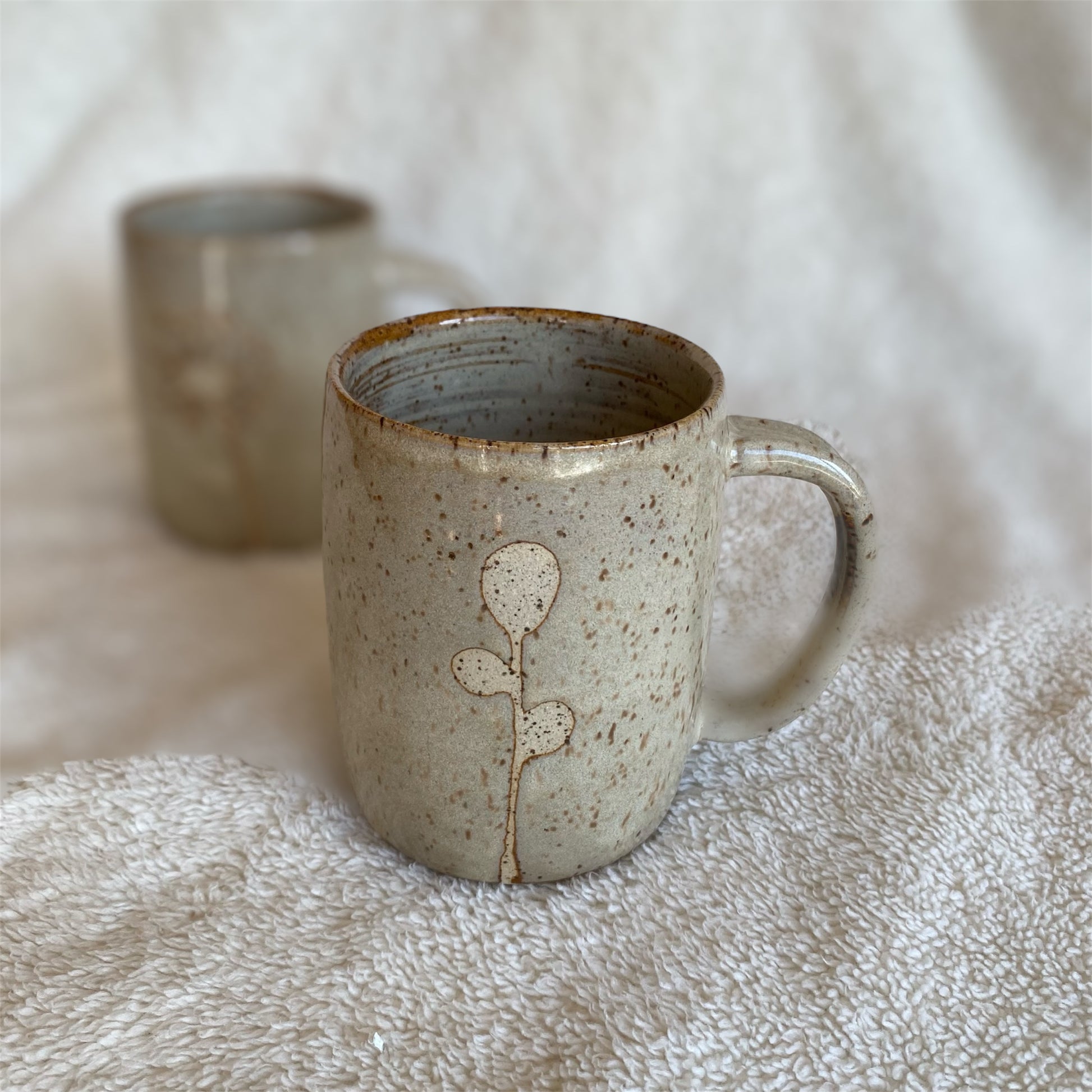 Ceramic mug with floral design on a textured surface